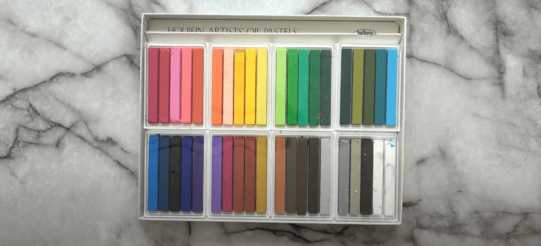 Photo of oil pastels neatly arranged inside their box
