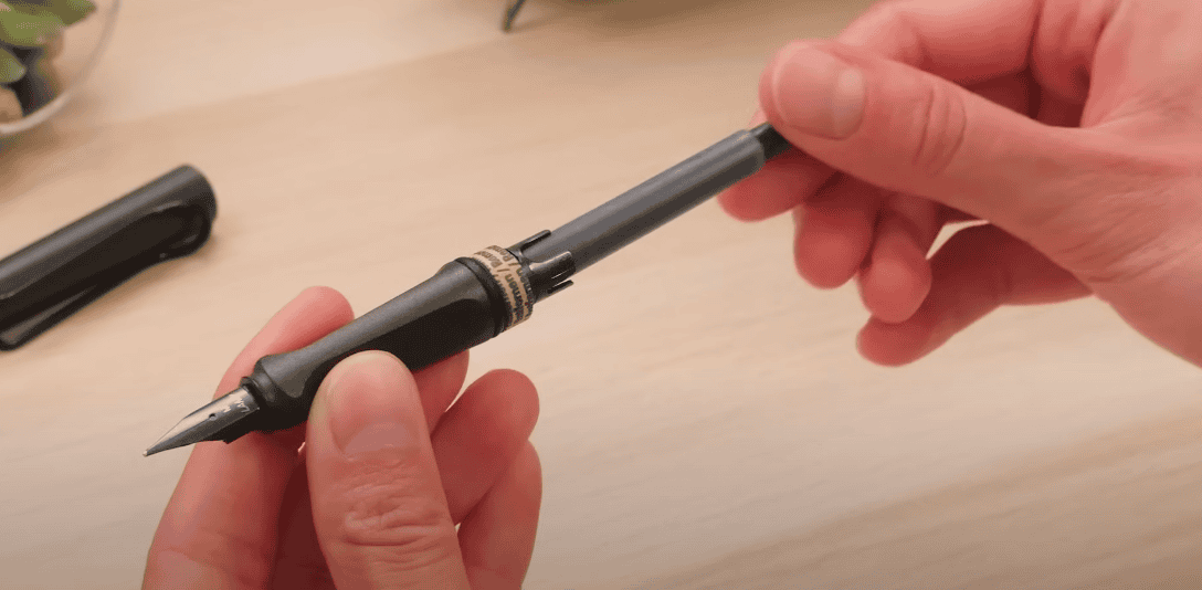 Photo of a black fountain pen being held by hands