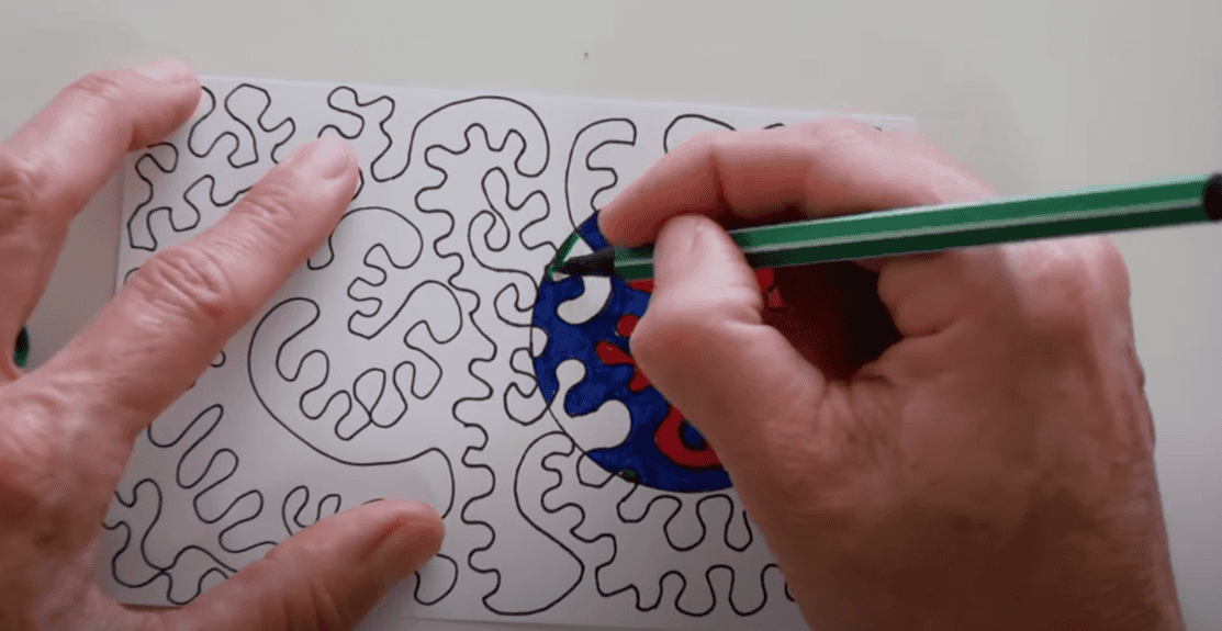 Photo of a hand creating a line drawing with vibrant colors, where some parts of the drawing are particularly vivid